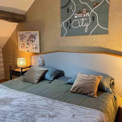 Chambre communicante de Sapin : deux lits habillés de blanc sous rampant, grande carte illustrée encadrée au mur.